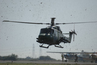 a Lynx helicopter with grass being blown about